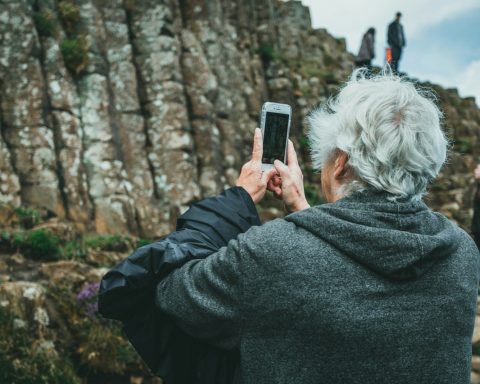 man in black hoodie holding smartphone