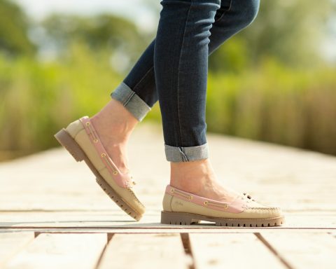 A person walking on a wooden platform in a park