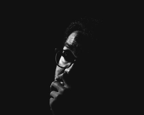 man wearing black sunglasses grayscale photo