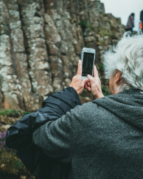 man in black hoodie holding smartphone