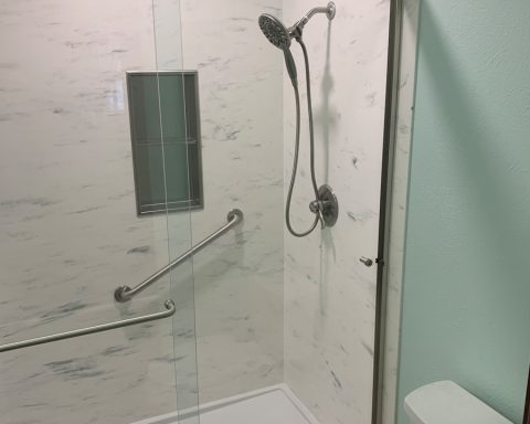 a bathroom with a glass shower door and a toilet
