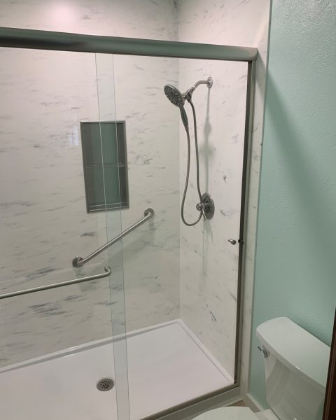 a bathroom with a glass shower door and a toilet