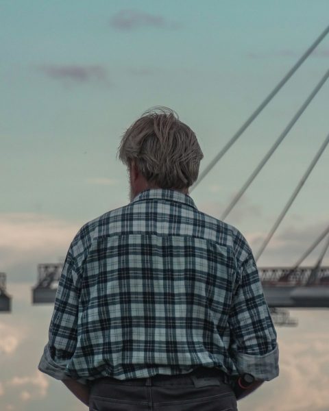 a man standing in front of a body of water