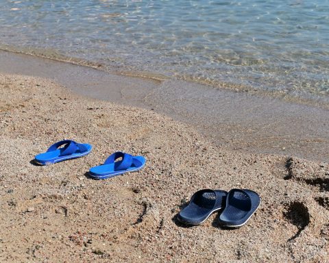 blue and black flip flops on beach
