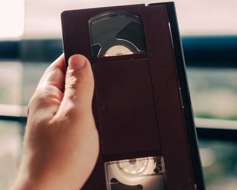 person holding black VHS tape