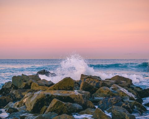rocks surrounded by ocean during sunset