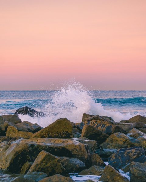 rocks surrounded by ocean during sunset