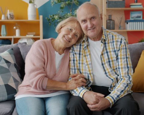Elderly couple smiling on a couch