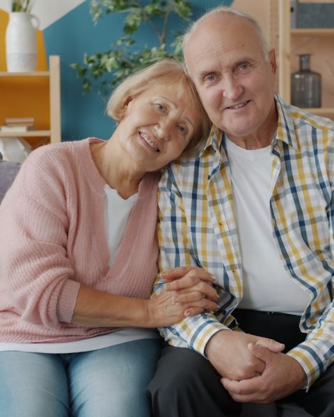Elderly couple smiling on a couch