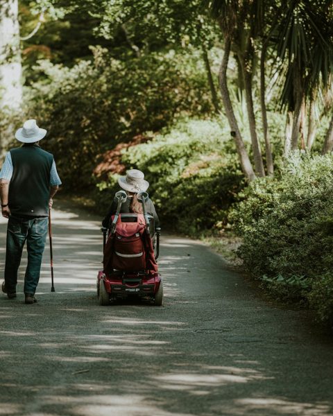 a man and a woman walking down a dirt road