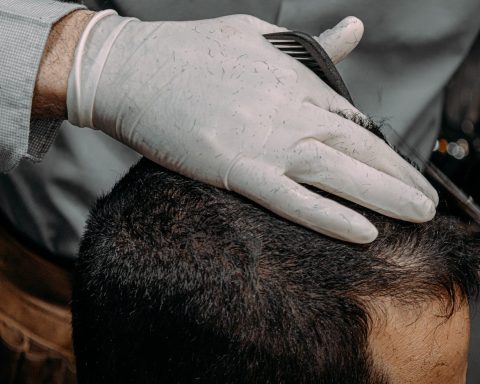 a close up of a person cutting another persons hair