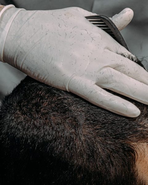 a close up of a person cutting another persons hair