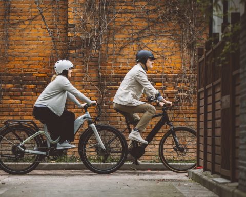 a couple of people riding bikes down a street