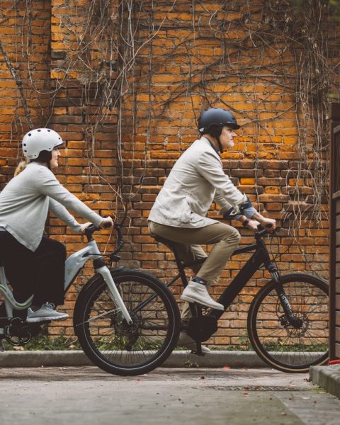a couple of people riding bikes down a street