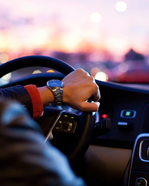 man driving a car wearing wrist watch