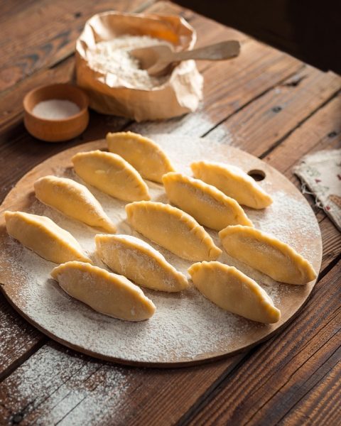 Oudere handen die een pan vasthouden in de keuken