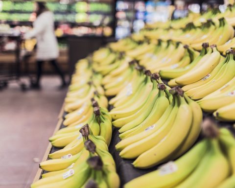 Senior leest het etiket op een verpakking in de supermarkt