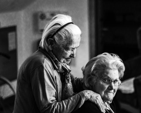 Een oudere vrouw ontvangt thuiszorg van een verpleegkundige in haar eigen woning
