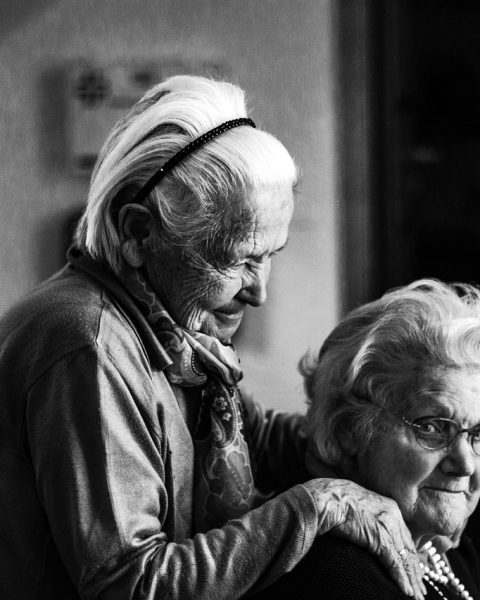 Een oudere vrouw ontvangt thuiszorg van een verpleegkundige in haar eigen woning