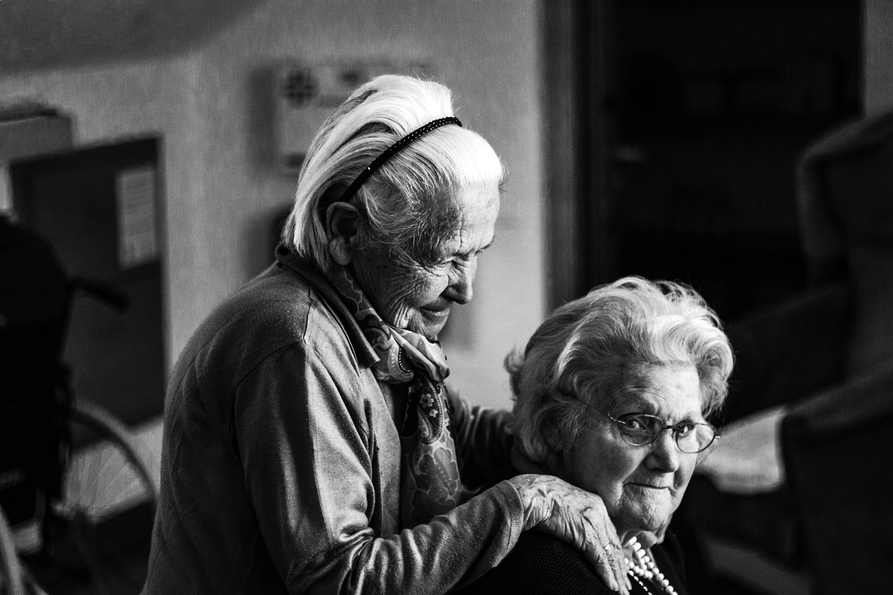 Een oudere vrouw ontvangt thuiszorg van een verpleegkundige in haar eigen woning
