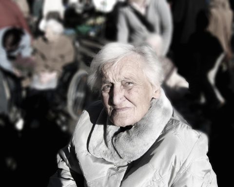 Een senior vrouw op groepsreis, lachend met medepassagiers tijdens een begeleid uitstapje