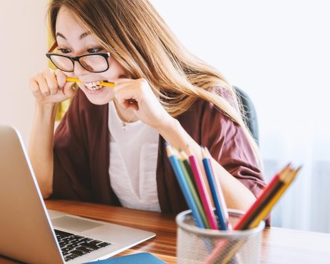 Een vrouw van boven de 55 jaar die achter een laptop studeert voor een omscholing