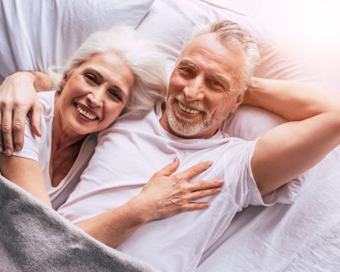 Senior die met plezier tuiniert bij een verhoogde plantenbak op tafelhoogte