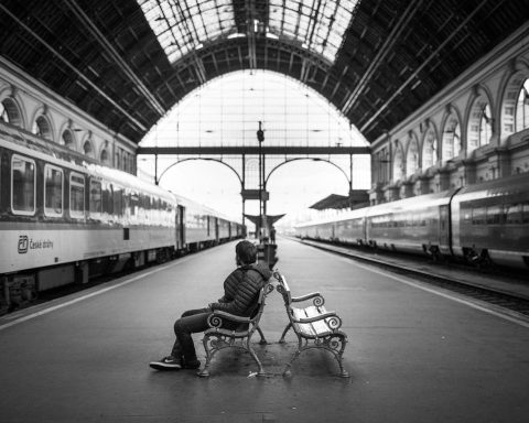 Senioren-echtpaar op een treinstation met koffers, klaar voor vertrek