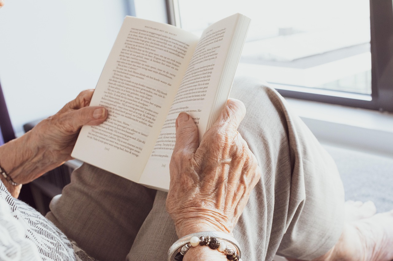 Een oudere vrouw leest een boek op een rustige plek in de buurt