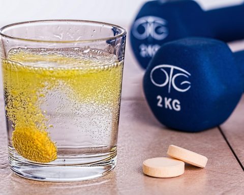 Senior die drinkvoeding drinkt aan de keukentafel