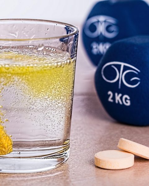 Senior die drinkvoeding drinkt aan de keukentafel