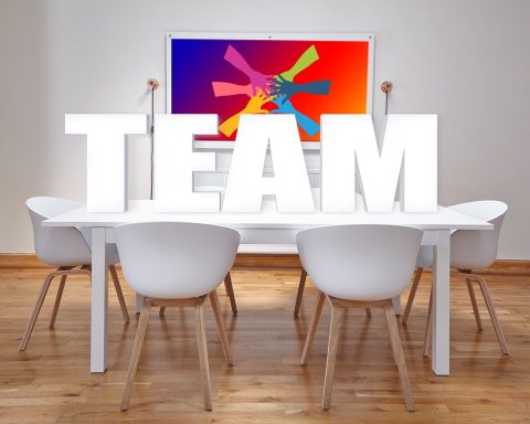 Groep senioren die samen aan tafel zitten tijdens een netwerkbijeenkomst