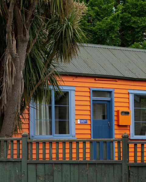 a small orange house with a blue door