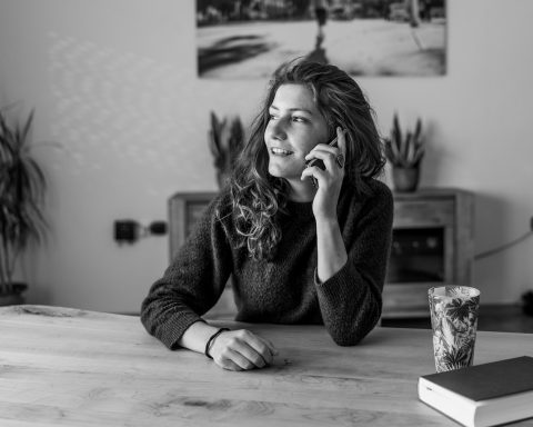Een oudere vrouw praat gezellig met een buurvrouw op de stoep