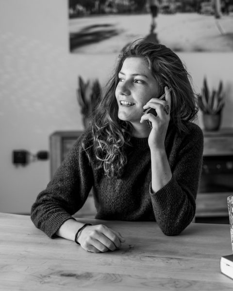 Een oudere vrouw praat gezellig met een buurvrouw op de stoep