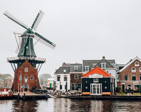 Een oudere man wandelt door een rustig Oost-Nederlands landschap met weilanden en bomen